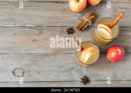 Seasonal apple drink. Spicy Apple Cider or Punch. Homemade apple cocktail on wooden background, copy space. Stock Photo