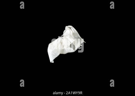 a crumpled paper napkin on a black insulated background. on the glass Stock Photo