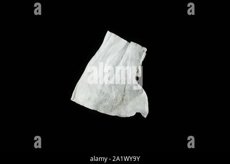 a crumpled paper napkin on a black insulated background. on the glass Stock Photo