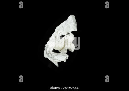 a crumpled paper napkin on a black insulated background. on the glass Stock Photo