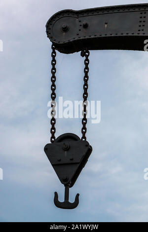 Old crane with chains made of steel Stock Photo