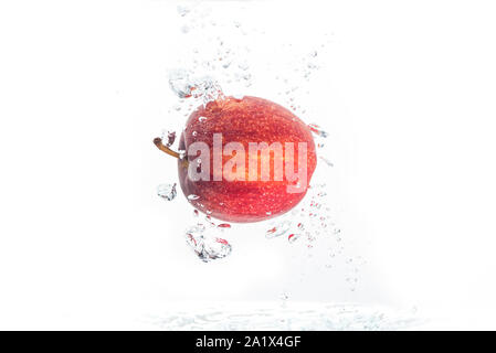 Apple falls under water with a splash. Stock Photo
