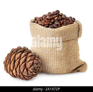 unpeeled cedar nuts in burlap sack and pine cone isolated on white background Stock Photo