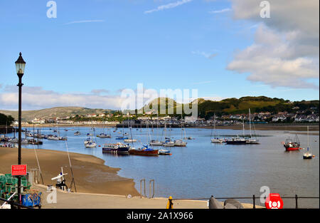The view on a bay with a lot of boats on the river Conwy during a low tide. Conwy, Wales / United Kingdom Stock Photo