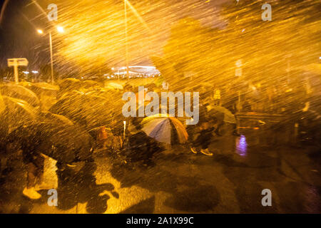 Hong Kong, China. 28th Sep, 2019. Crowds of protesters shield themselves from sprays of water with umbrellas during the demonstration.During the 17th weekend of consecutive demonstrations, protesters attend a rally marking the 5th year anniversary of the Umbrella Revolution. They chanted slogans and continued to ask for the five demands to be met. Later in the night, protesters clashed with riot police and eventually fled after being sprayed by water cannons. Credit: Willie Siau/SOPA Images/ZUMA Wire/Alamy Live News Stock Photo