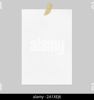 Empty white paper sheet on light gray background with brown adhesive tape, front view A4 poster mockup Stock Photo
