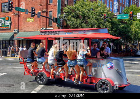 Nashville, TN, USA - September 21, 2019:  Revelers enjoy drinks on a Sprocket Rocket pedal bike tavern on Broadway Street.  These vehicles are powered Stock Photo