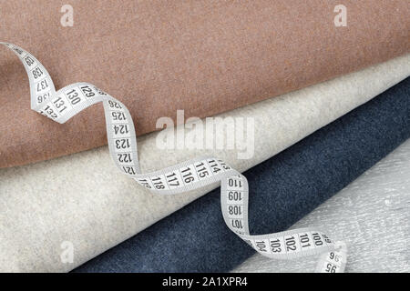 Three knitted multicolored fabrics and measuring tape close up. Stock Photo
