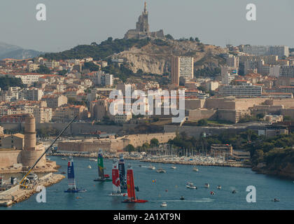The fleet sail during a practice race ahead of the final SailGP in front of Basilica Notre Dame de la Garde in Marseille Stock Photo