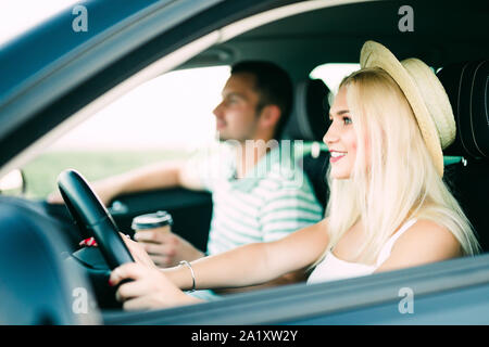leisure, road trip, travel, family and people concept - happy man and woman driving in car Stock Photo
