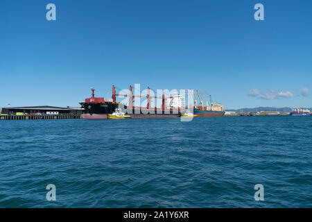 Tauranga New Zealand - September 21 2019; Port of Tauranga wharf with cargo vessel moored alongside and two pilot boats. Stock Photo