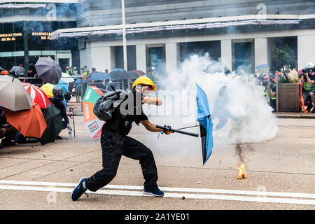 A protester throws back a tear gas canister during the demonstration.During the 17th weekend of consecutive demonstrations, protesters marched as part of a global anti-totalitarianism initiative. Demonstrators chanted slogans and continued to ask for the five demands to be met. Protesters clashed with riot police and were hit with tear gas, rubber bullets, and a water cannon until several were eventually arrested. Stock Photo