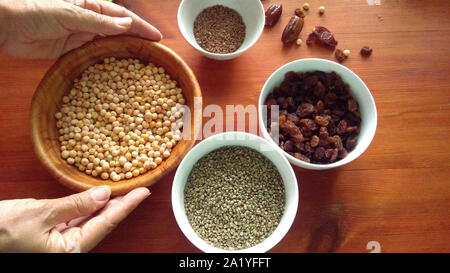 Assortment of dried peas, hemp, flaxe, raisins on wooden table Stock Photo
