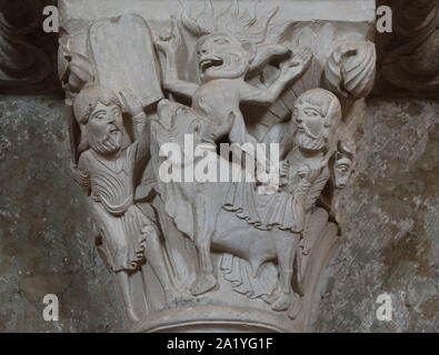 Moses and the Golden Calf depicted in the Romanesque capital dated from the 12th century in the Basilica of Saint Mary Magdalene (Basilique Sainte-Marie-Madeleine de Vézelay) of the Vézelay Abbey (Abbaye Sainte-Marie-Madeleine de Vézelay) in Vézelay, Burgundy, France. At Mount Sinai Moses discovers his people worshipping an idol of a golden calf. On the left Moses holds up the tablets of the Ten Commandments and raises a stick to destroy the idol, while a demon leaps from the calf's mouth. On the right a Hebrew brings a ram for sacrifice. Stock Photo