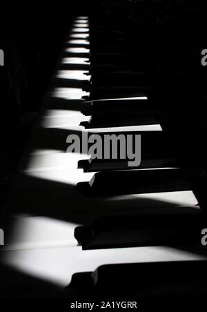 Piano keyboard under diagonal light with shadows Stock Photo