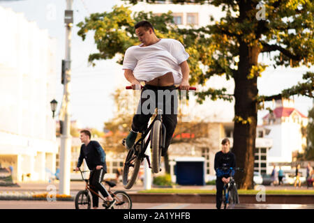 The guy performs a stunt on BMX, jumping up. Stock Photo
