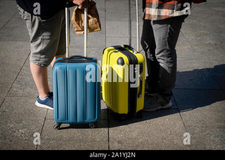 Unrecognizable two young men, travelers standing near a suitcases, summer sunny day, travel and tourism concept Stock Photo