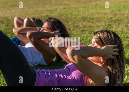 Three Caucasian women in the park, two blondes and one brunette working out in the park. Sport, health and lifestyle concept Stock Photo