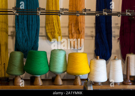 Colorful spools and hanks of wool on display in a workshop at the Ethnographic Museum of Grandas de Salime. The historic village is a popular stop on Stock Photo