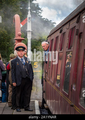Guard on platform next to train carriage, Goathland station, North Yorkshire Moors Railway, UK. Stock Photo