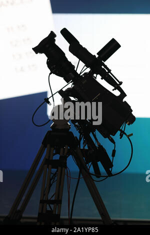 Professional TV camera on the tripod before news briefing. Stock Photo