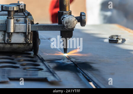 Motswana welder worker in a Botswana workshop, using an acetylene torch to cut in straight line, roller torch, Stock Photo