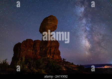 Iconic Balanced Rock silhouetted against a star-filled Milky Way in Arches National Park in Moab, Utah. Stock Photo