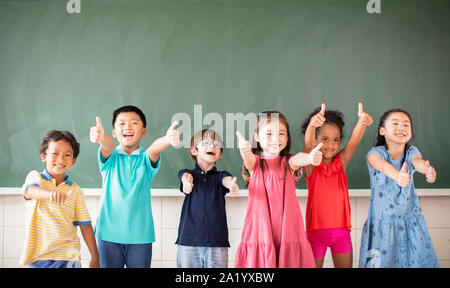 Multi-ethnic group of school children standing in classroom Stock Photo