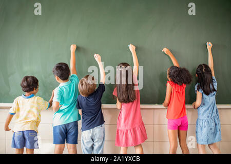 Multi-ethnic group of school children drawing on the chalkboard Stock Photo