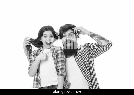 He envies my hairstyle. Man with beard and little girl long hair on white background. Father play with hair of kid. Hairdresser and barber concept. Having fun with long hairstyle. Hair care. Stock Photo