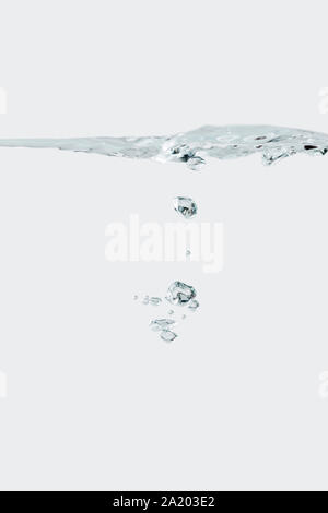 Studio shot of small rising air bubbles isolated against white background. Stock Photo