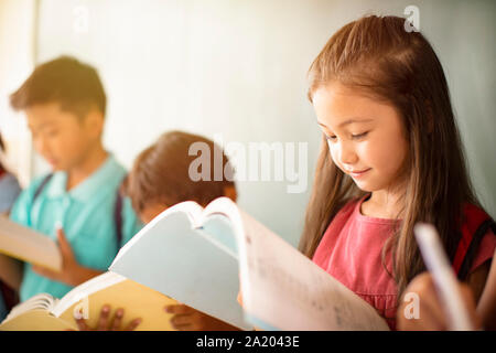 Group of diverse young students studying in  classroom Stock Photo