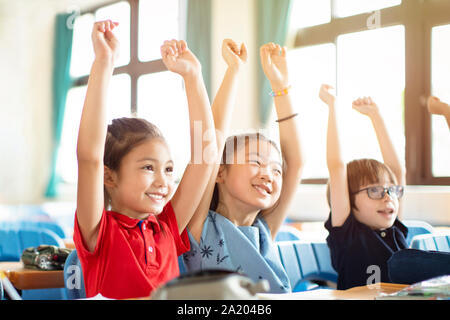 Smiling elementary school kids  in classroom Stock Photo