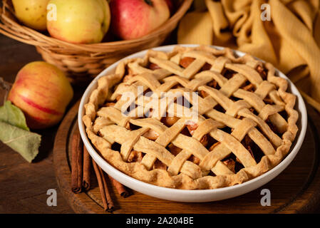 Homemade apple pie with lattice on top on wooden table background. Traditional american comfort food, autumn fall dessert. Stock Photo