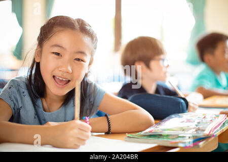 Smiling elementary school kids  in classroom Stock Photo