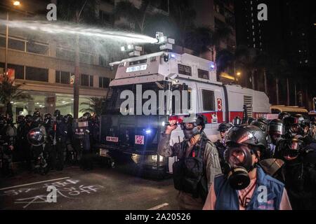 Hong Kong, China. 29th Sep, 2019. Riot police uses water cannon truck to extinguish fire and open the streets of Wan Chai during the demonstration.Protesters attend a Global Anti-Totalitarianism March in Hong Kong - Demonstrations continue in Hong Kong marking one of the worst days of violence in 4 months of unrest. Credit: SOPA Images Limited/Alamy Live News