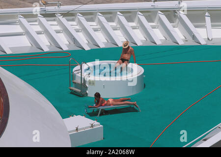 Ibiza, Spain - Jul 03, 2019: Man and woman by  pool on deck of cruise liner Stock Photo