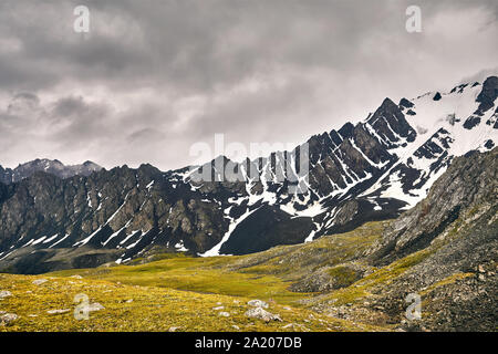 Dramatic scenery rocky mountains at overcast sky in Altyn Arashan George, Kyrgyzstan Stock Photo