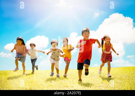 Multi-ethnic group of school children laughing and running Stock Photo