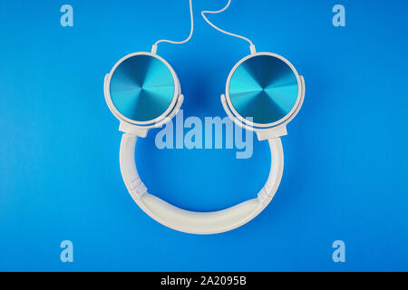 blue white color headphone on a blue background Stock Photo