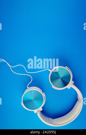 blue white color headphone on a blue background Stock Photo