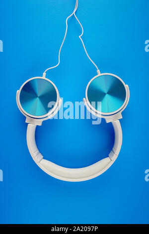 blue white color headphone on a blue background Stock Photo