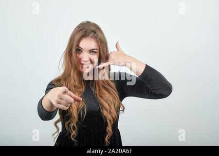 girl brown haired in black dress over isolated white background shows emotions Stock Photo