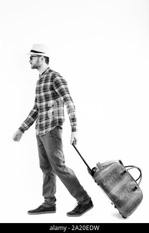 Full body shot of profile view of young man carrying bag ready for vacation Stock Photo