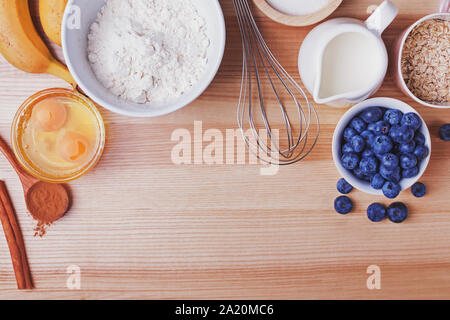 Ingredients for blueberry muffins preparation on wooden table, top view. Stock Photo
