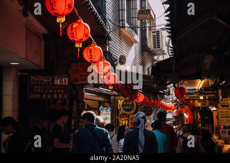 Jiufen, Taiwan - November 07, 2018: People walk with purchases along the crowded Old Street market on November 7, 2018, in Jiufen, Taiwan Stock Photo