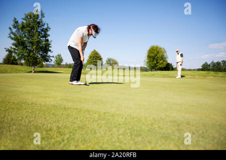 Two senior golf player on green. Stock Photo