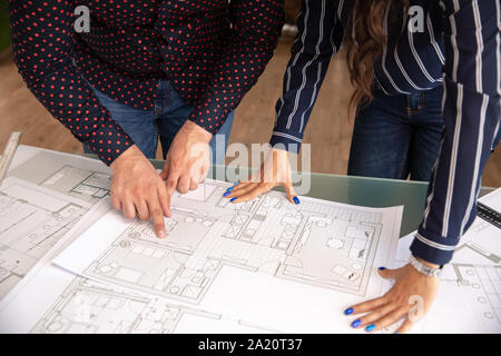 Close up with the hands of two architects browsing some sheets. New project Stock Photo