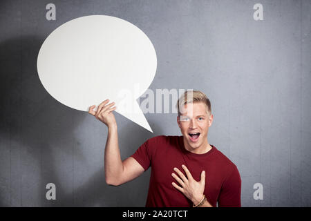 Joyful man holding empty speech bubble. Stock Photo