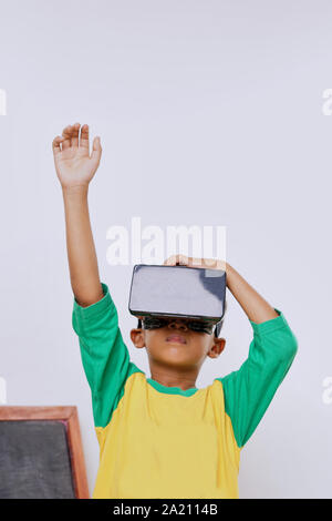 Schoolboy standing using virtual reality glasses on white background Stock Photo